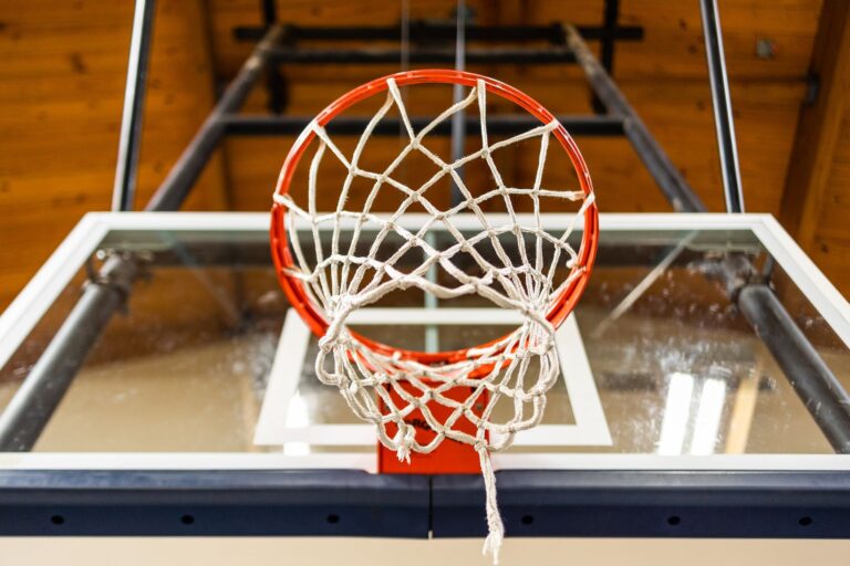 Dynamic shot of a basketball hoop viewed from below, showcasing the net and backboard.